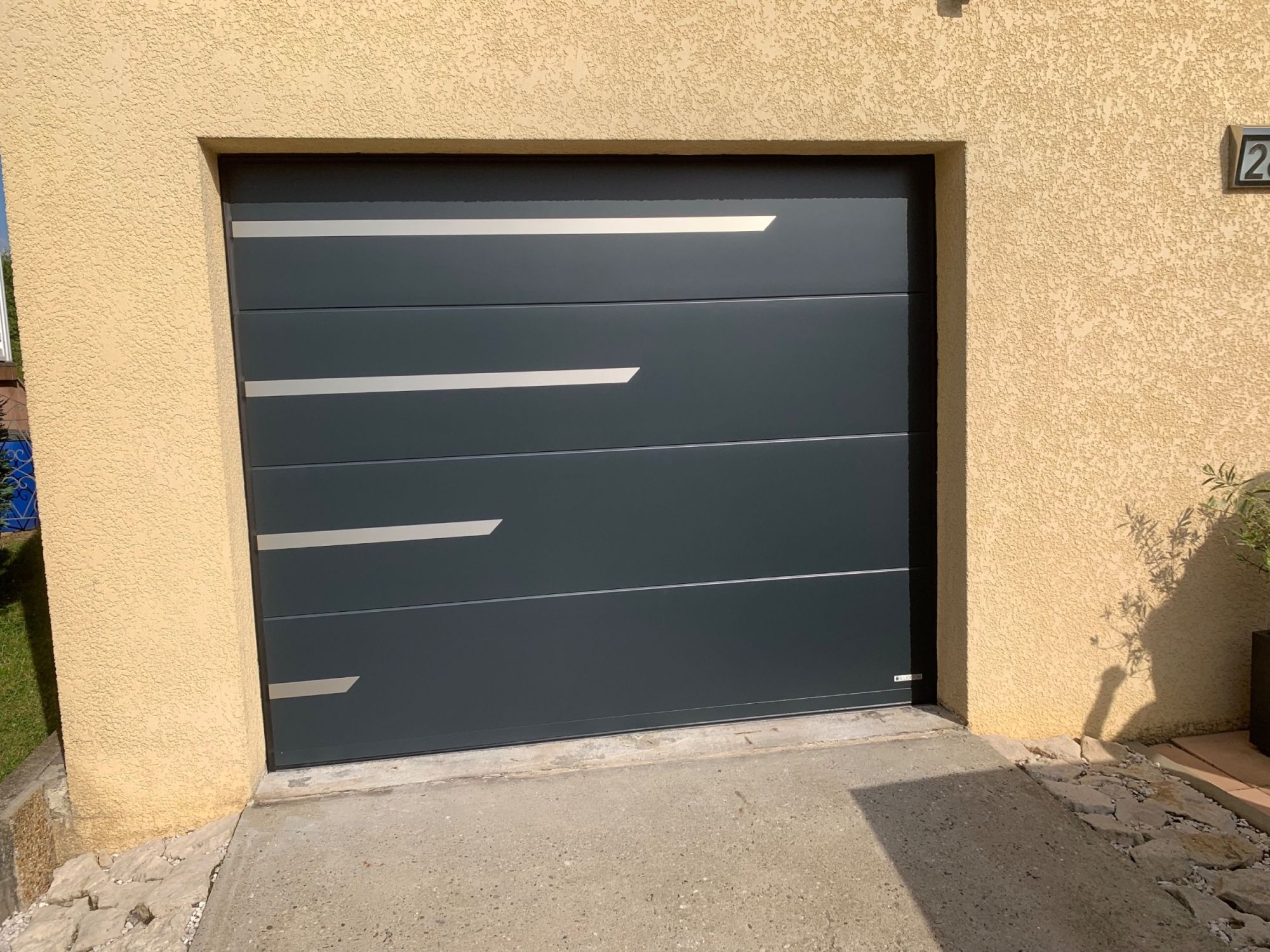 Porte de garage aluminium gris anthracite avec motif inox